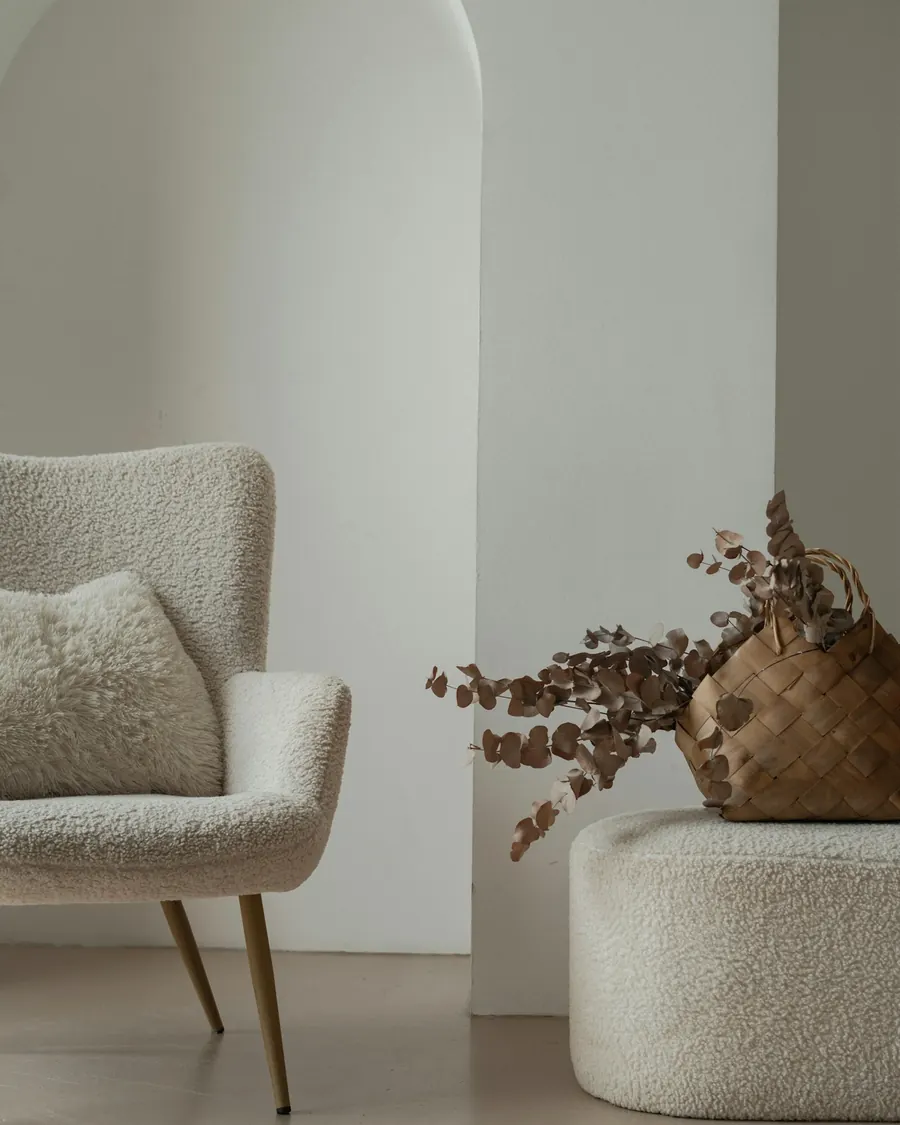 Textured armchair beside a vase in a pale interior