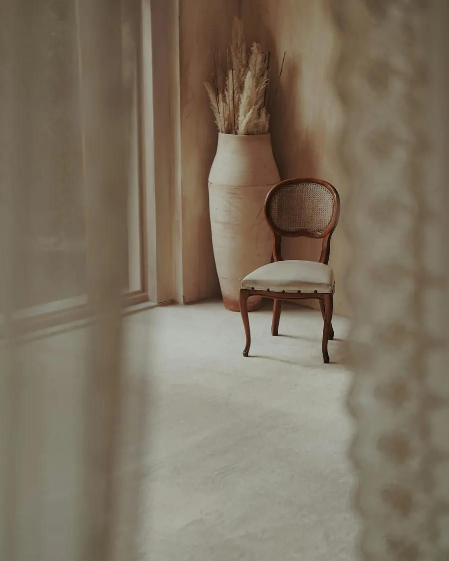 A vintage chair and a vase with pampas grass